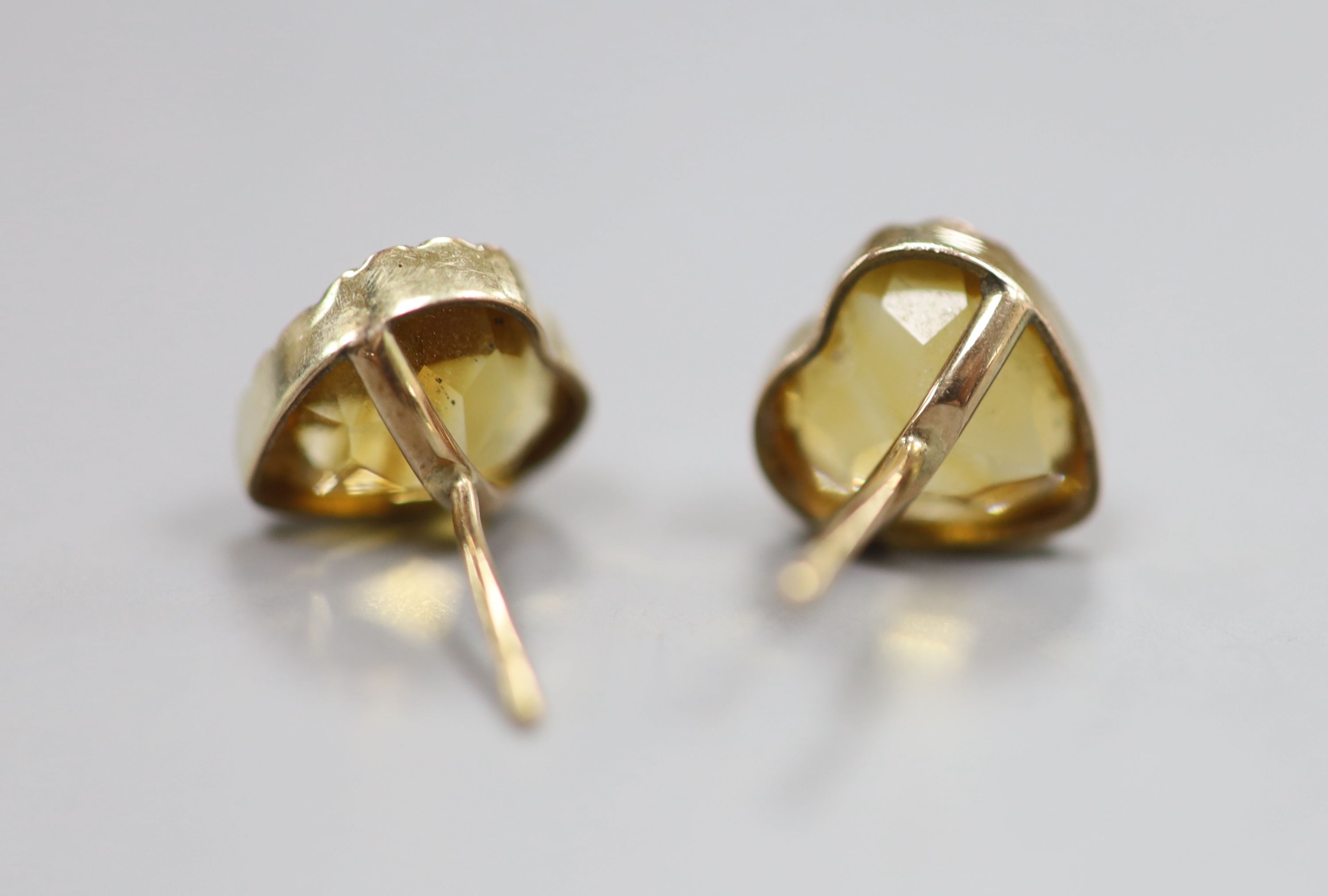 A yellow metal and heart shape citrine pendant, 10mm and pair of matching ear studs(no butterflies), gross 3.6 grams.